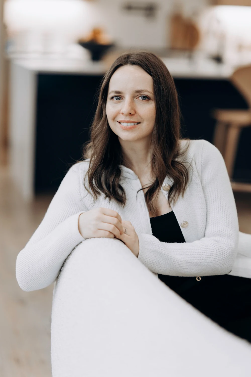 Katerina Fateev seated in a cream cardigan